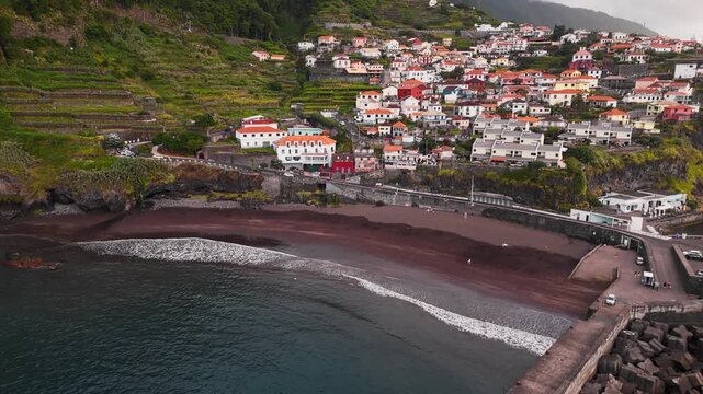 Seixal black sand beach in Madeira, Portugal, aerial view. Volcanic shoreline beside coastal village on north coast of island