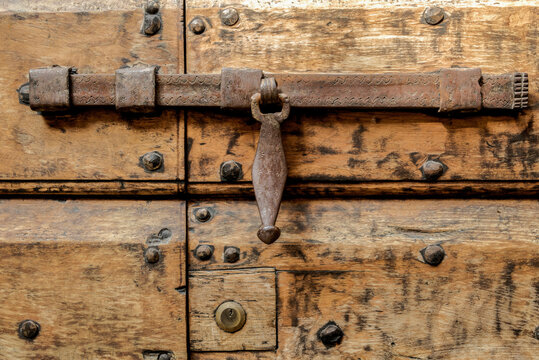 antique large door with a metal bolt fastening