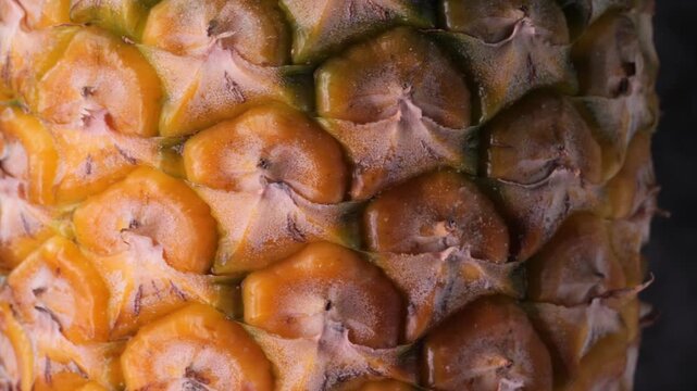 close-up rotating macro shot of pineapple skin, showing detailed texture and pattern.	
