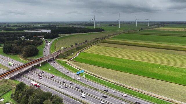 Traffic at a highway junction near Zwolle where the A28 and the A50 highways cross with a railroadbridge in the foreground in Overijssel The Netherlands.