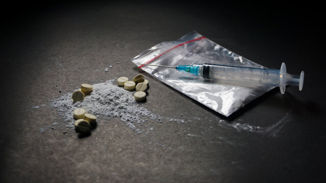 syringe and pills, white powder and medical plastic clip. Illegal and misused drugs concept. 