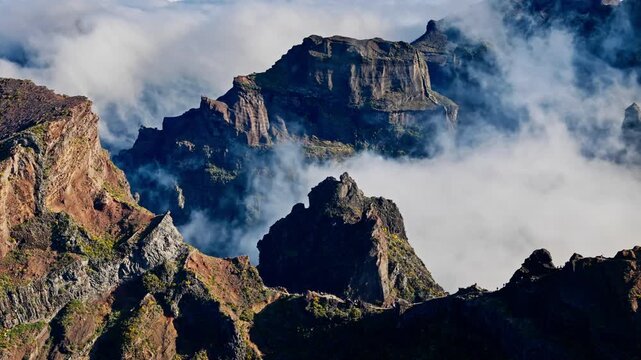 Pico do Arieiro rock formations with layered cliff walls and clouds, Madeira, Portugal. Mountain geology and natural island landmark