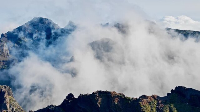 Pico do Arieiro ridgeline above cloud-filled valleys, Madeira, Portugal. Rugged mountain terrain and island sightseeing destination.
