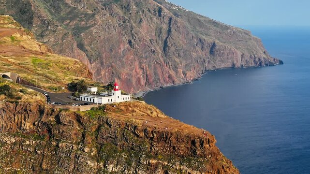 Ponta do Pargo lighthouse and clifftop viewpoint above rugged shoreline, Madeira, Portugal. Aerial footage of western island coast and Atlantic headlands