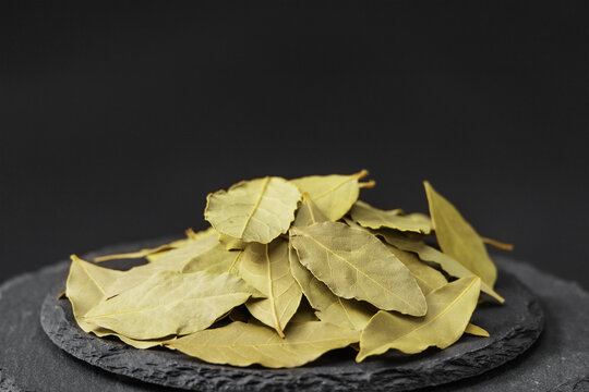 fragrant dried bay laurel leaves on a black slate stone tray