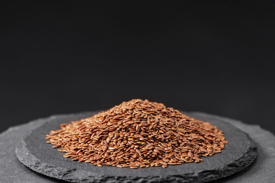 flax seeds of the plant Linum usitatissimum on a black slate stone tray