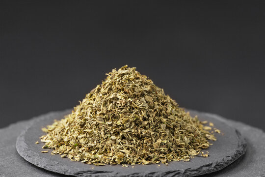 legume plant fenugreek leaves flakes on a black slate stone tray