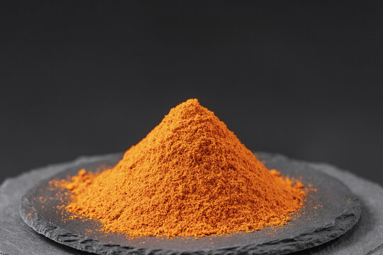 hot chili pepper cayenne powder on a black slate stone tray