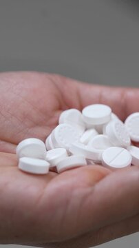 close up woman hand holding a medicine, with pours the pills out of medicine bottle. Stop drug use Taking Medication Caring for the health care medical concept.