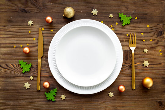 Christmas and New Year Eve table setting flatlay. Empty plate with cutlery and decoration, top view