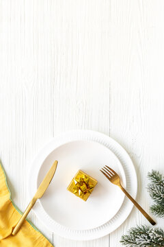 Festive Christmas table setting with yellow and gold colored decoration. Top view