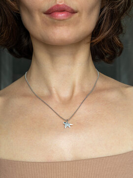 Stylish woman wearing steel chain - modern minimalist jewelry fashion portrait in natural light