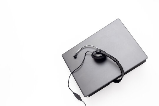 Customer support workspace with laptop and headset - remote call center service concept, top view office flat lay
