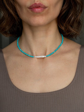 Bohemian gemstone choker on young woman - natural stone turquoise jewelry portrait with artistic beauty and soft daylight
