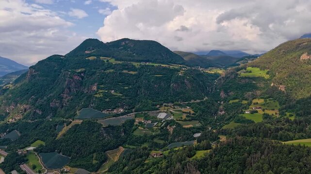 Drone timelapse of a mountain valley in South Tyrol, Italy. Clouds pass over the rural landscape of the Dolomite Alps