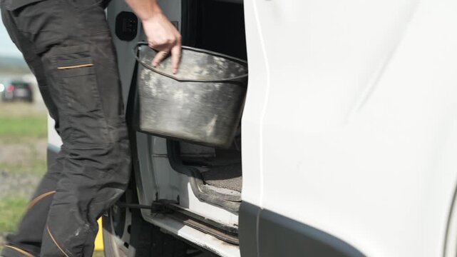 Worker steps into van, gripping tools with purpose
