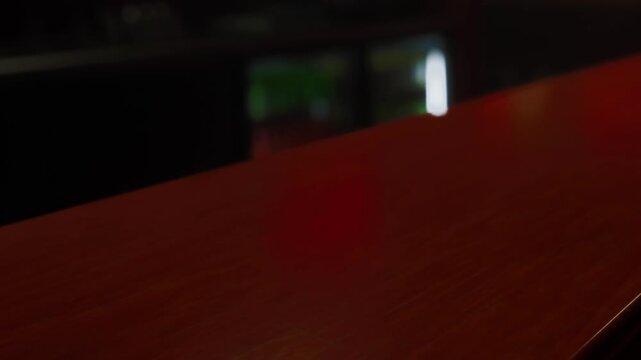 A warm and inviting bar setting features a polished wooden countertop. Soft lighting creates a relaxed atmosphere, ideal for casual conversations and enjoying drinks with friends.