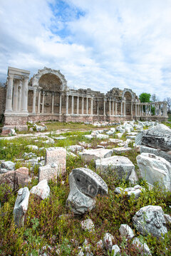 The Ancient City of Side. This photograph shows the remains of an ancient Nymphaeum (monumental fountain). In the background, there are columns, arches, and the tall, majestic stone fa&ccedil;ade of the anci