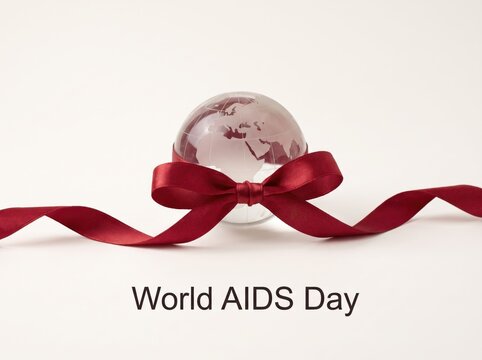 World aids day concept with glass globe and red ribbon symbol on white background banner and card