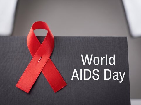 World aids day concept with red ribbon symbol on dark background for health awareness campaign