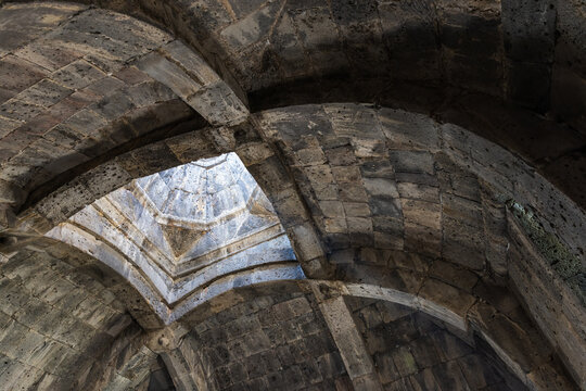 Ancient stone vault featuring ribbed arches and an octagonal skylight pouring soft light into a historic Haghpat Monastery built between the 10th and 13th century also known as Haghpatavank, Armenia