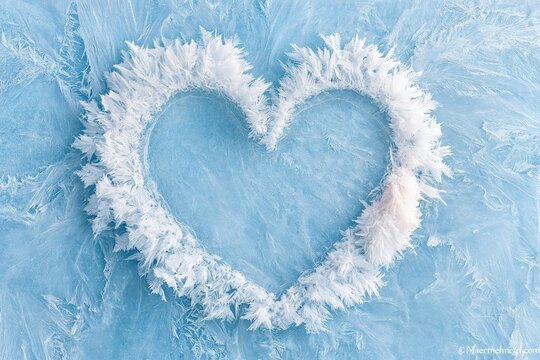 Frosty Heart Shape on Blue Ice Background for Winter Holiday Design