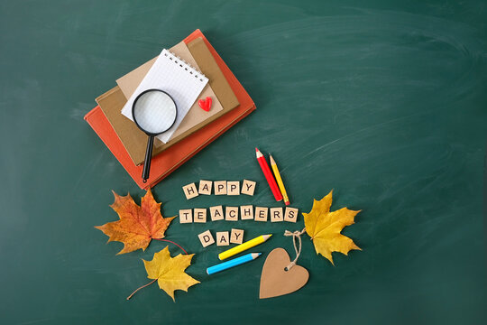 Happy teacher's day greeting card. school stationery, maple leaves, loupe, pencils,learning books on chalkboard background. Teacher's day holiday, 5 october. flat lay. template for design