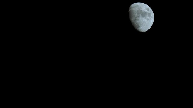 Close up shot of a gibbous moon crossing through the frame