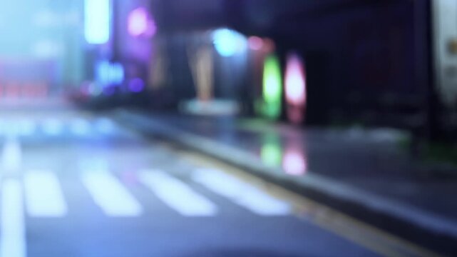 Neon lights create a colorful glow on slick pavement in an empty urban street. The atmosphere feels quiet, serene, and a bit mysterious under the night sky.
