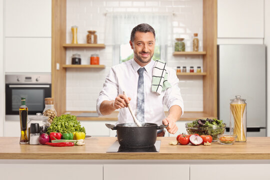 Man cooking a meal in a pot with a wooden spoon