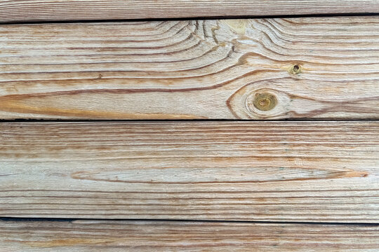 Natural light brown wooden planks with visible grain texture forming a simple horizontal wall background