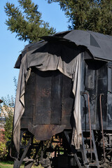 Steam locomotives. Museum complex of the locomotive depot Podmoskovnaya. Old steam locomotive wheels. The entrance to the old locomotive's cab is covered with a cloth to block the sun. © VLAD ANTONOV