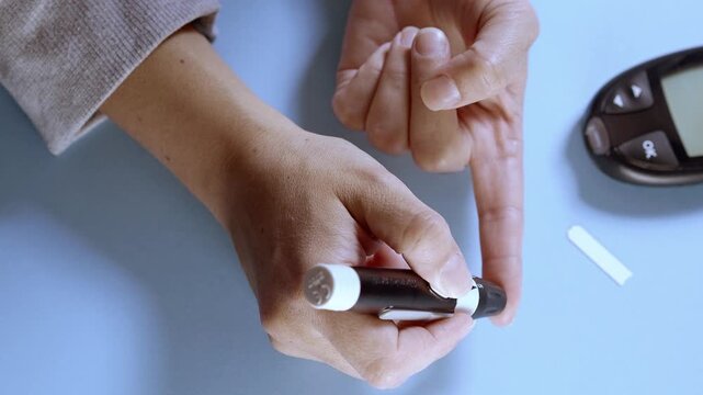 Person with diabetes measuring blood sugar level with glucometer