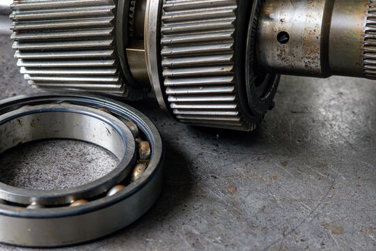 Disassembled spline shaft, planetary gear, and ball bearing rest on a workshop bench.