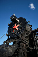 Steam locomotives with red star stands on a blue sky. Retro steam train.  © VLAD ANTONOV