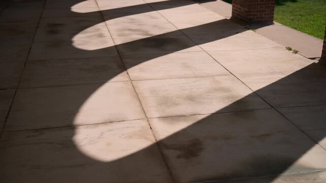 Artistic shot of sunlight and column shadows falling across the stone patio at the Hall of Springs in Saratoga Springs, New York, creating dramatic geometric patterns.