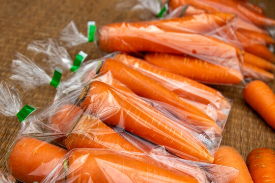 Bundles of fresh carrots wrapped in clear plastic