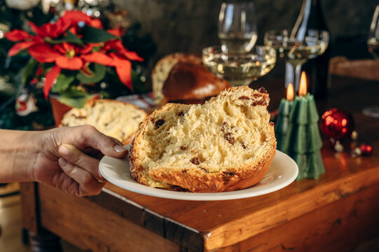 Festive Christmas Table With Sliced Panettone, Candle, Wine Glasses and Decorated Tree
