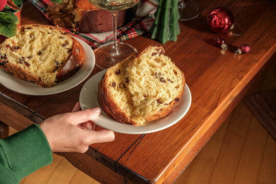 Festive Christmas Table With Sliced Panettone, Candle, Wine Glasses and Decorated Tree