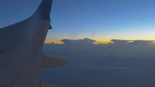Wing of plane with sunsetting clouds