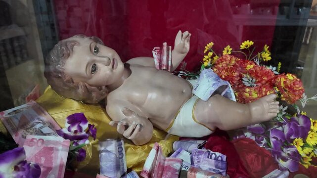 Baby Jesus statue with money offerings at Simala Shrine in Cebu