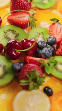 Background of fresh fruits and berries rotating. Vegan sweet food, flat lay.