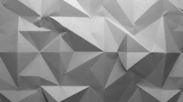 Abstract Grey Geometric Folded Paper Texture Background with Moving Light and Shadow, Monochrome Film Grain, Seamless Loop