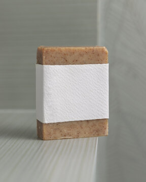 Brown handmade soap mockup with blank label in sage green bathroom, unbranded packaging