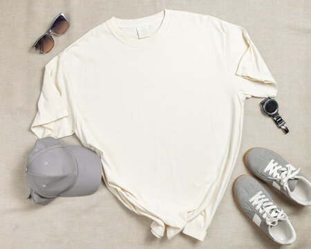 Blank ivory unisex t-shirt mockup, crewneck flat lay with denim jeans and mens accessories