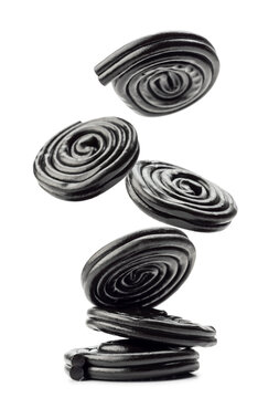Liquorice candy wheels jumping, isolated on white background.
