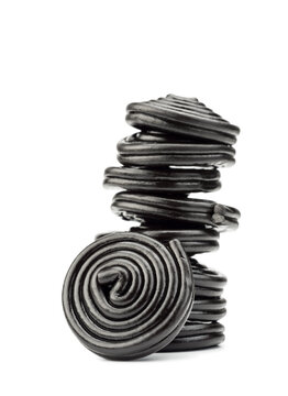 Liquorice candy wheels pile, isolated on white background.