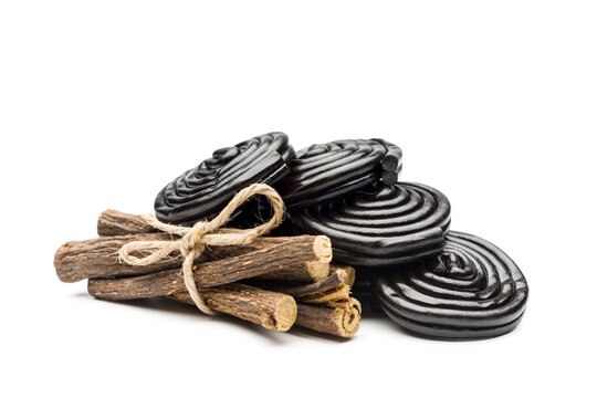 Liquorice candy wheels bunch with liquorice roots, isolated on white background.