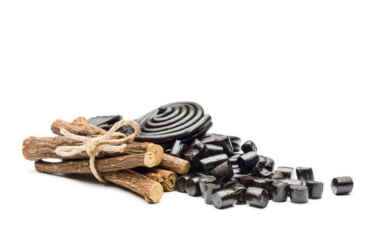 Liquorice candy wheels bunch with liquorice roots, isolated on white background.
