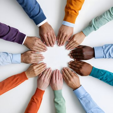 Top-down photograph of hands from a multicultural team arranged in a radial pattern, unity collaboration and diversity concept, colorful clothing details, clean background, commercial stock aesthetic,